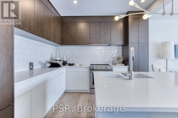Modern kitchen with white quartz countertops, dark wood cabinets, stainless steel appliances, and white subway tile backsplash. - 406 Green Gate Boulevard, Cambridge