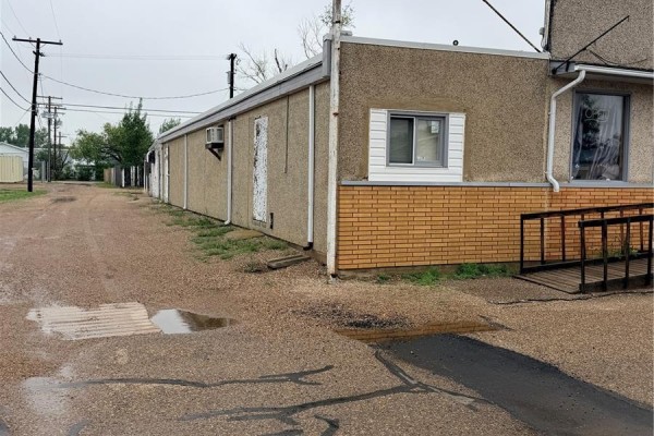 Commercial building exterior from the side, showing tan stucco, brick base, and a ramp to the entrance. - 406 Martin Street, Burstall