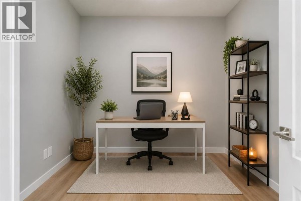 Home office with a desk, chair, laptop, shelving unit, and a large landscape painting. - 406 South Shore Drive, Chestermere