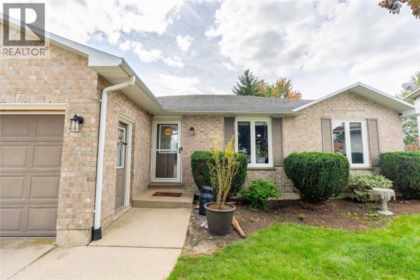 Close-up view of the front entrance of a brick home with a beige door and windows. - 4069 Pine Crescent, Petrolia