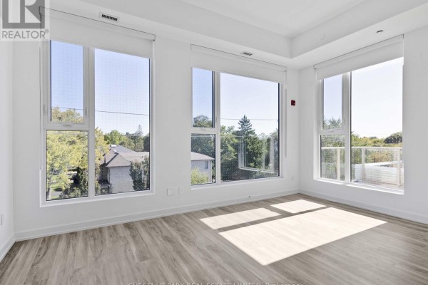 Corner room with multiple large windows offering views of trees and houses. - 407 - 722 Marlee Avenue, Toronto