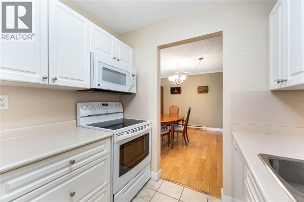 View of kitchen appliances and a doorway leading to a dining room. - 407 2125 Oak Bay Ave, Oak Bay