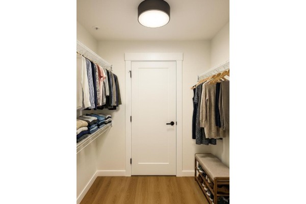 Walk-in closet with wire shelving, hanging clothes, a bench, and a shoe rack. - 407 27215 Aldergrove Town Centre Drive, Langley