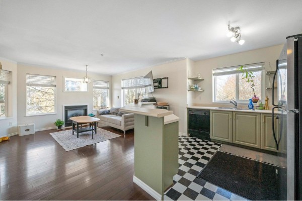 Living and dining area with a table, chairs, sofa, fireplace, and balcony access. - 407 33407 Tessaro Crescent, Abbotsford