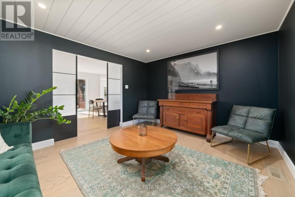 Living room with green sofa, wooden coffee table, oriental rug, and artwork - 407 County Road 4 Prince Edward County