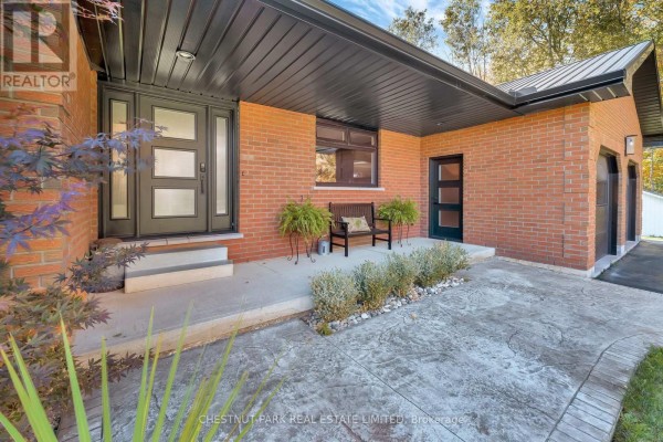 Modern home with brick exterior, black metal roof, and glass-panel door - 407 County Road 4 Prince Edward County