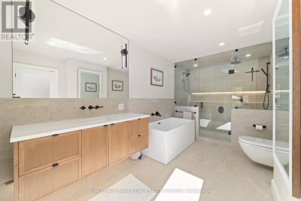 Modern bathroom with freestanding tub, glass shower, and double vanity - 407 County Road 4 Prince Edward County