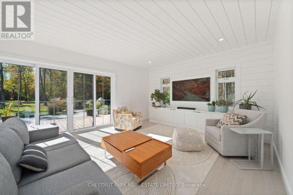 Modern living room with sectional sofa, coffee table, armchair, and wall TV - 407 County Road 4 Prince Edward County