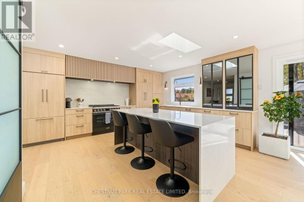 Modern kitchen with island, skylight, and hardwood floors - 407 County Road 4 Prince Edward County