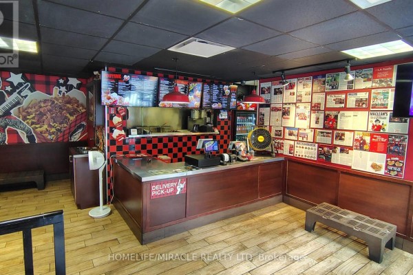 Interior view of the counter area with menu boards, stainless steel surfaces, and wooden paneling. - 407 Dalhousie Street, Ottawa