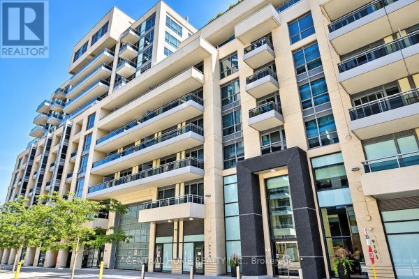 Front entrance of a contemporary apartment building with glass doors and stone accents. - 407 Se - 9199 Yonge Street, Richmond Hill