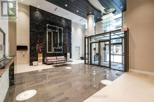 Luxurious lobby with a reception desk, modern sofa, and dark granite accent wall. - 407 Se - 9199 Yonge Street, Richmond Hill