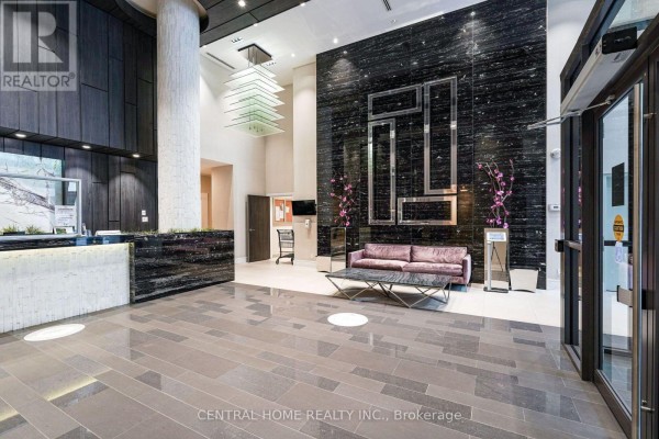 Spacious lobby with a reception desk, contemporary seating, and a dramatic stacked light fixture. - 407 Se - 9199 Yonge Street, Richmond Hill