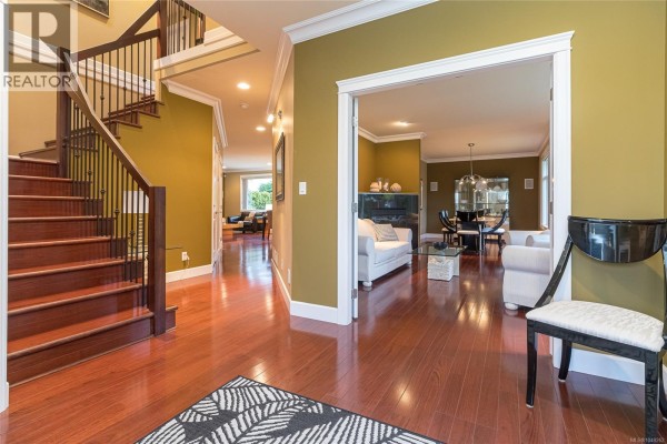 Entryway with hardwood flooring, green walls, and a view into the living area. - 4073 Longview Dr, Saanich
