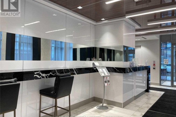 Shiny white reception desk with black marble accents and two black bar stools. - 408 - 32 Forest Manor Road, Toronto