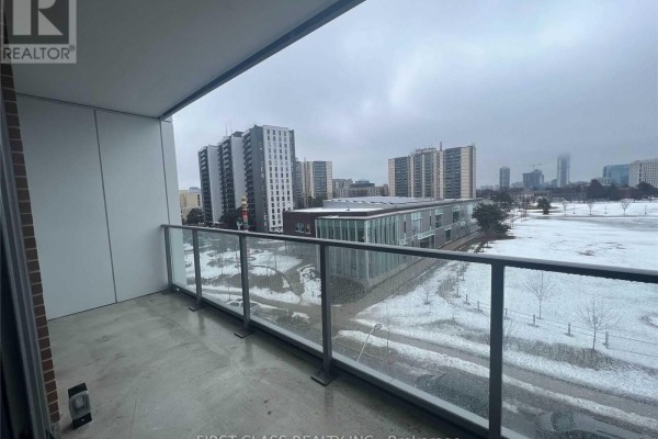 Balcony with glass railing overlooking a snowy park and surrounding apartment buildings. - 408 - 32 Forest Manor Road, Toronto