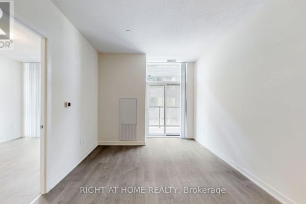 Empty room with a vent and sliding glass doors opening onto a balcony. - 408 - 38 Annie Craig Drive, Toronto
