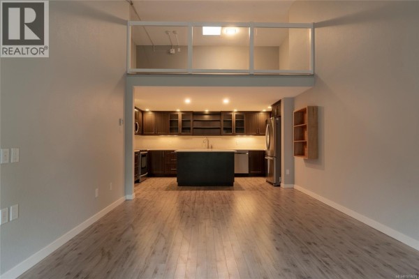 Modern kitchen with dark cabinetry, stainless steel appliances, and an island. - 408 1005 Mckenzie Ave, Saanich