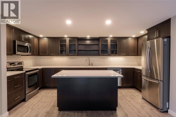 Open living space with high ceilings, overlooking the kitchen area. - 408 1005 Mckenzie Ave, Saanich