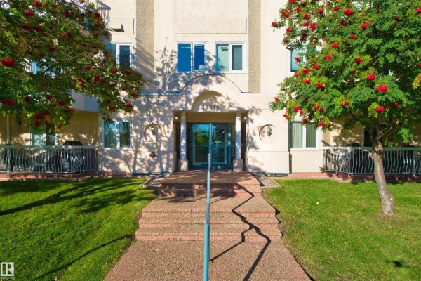 Close-up view of the apartment building entrance with glass doors and a walkway. - #408 10610 76 St Nw, Edmonton