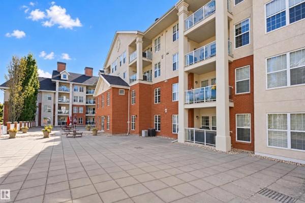 Side view of a brick apartment building with multiple balconies and large windows. - #408 45 Inglewood Dr, St  Albert