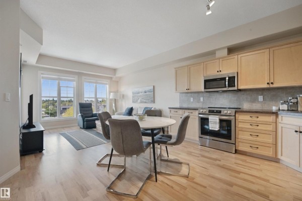 Open concept living and kitchen area with light wood floors and beige walls. - #408 45 Inglewood Dr, St  Albert