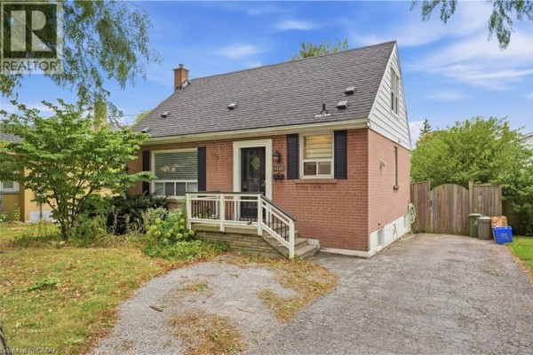 Side exterior of a red brick bungalow, showing the driveway and part of the backyard. - 408 Sanatorium Road, Hamilton