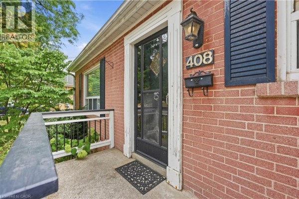 Close-up of the front door of a red brick house with black shutters and a mailbox. - 408 Sanatorium Road, Hamilton
