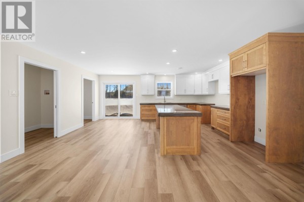 Spacious kitchen with white cabinets, wood island, and large windows. - 40883 Western Road Rte. 2, Alma