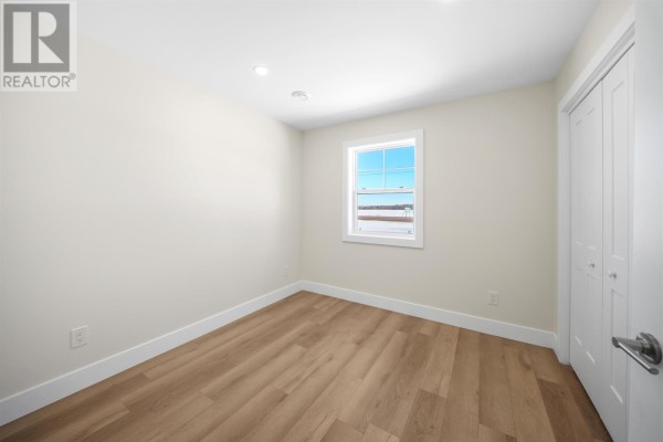 Bedroom with light wood floors, white walls, and a double bi-fold closet. - 40883 Western Road Rte. 2, Alma