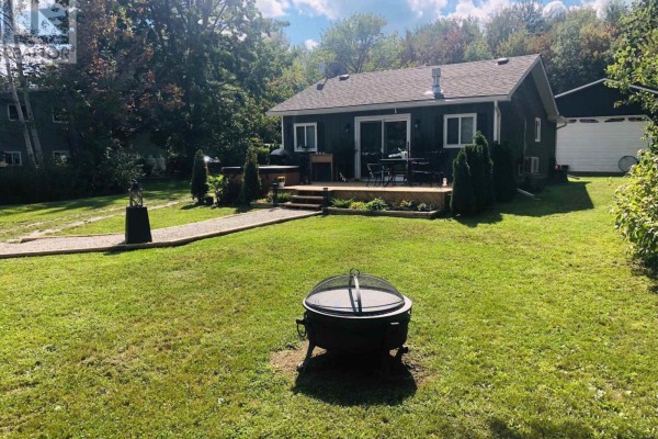 Rear exterior of a small house with a deck and hot tub. - 4089 Glen Cedar Drive, Ramara