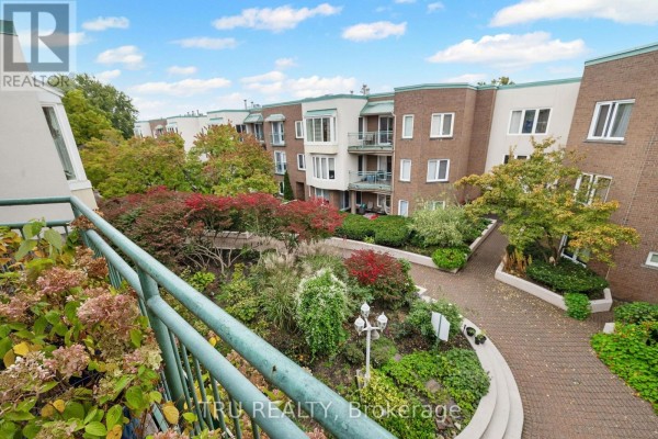 View of the apartment building courtyard with walkways and gardens from a balcony. - 408a - 62 Donald Street, Ottawa