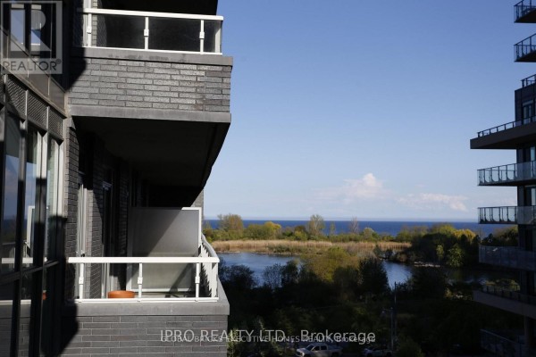 View from a balcony overlooking a calm body of water and distant shoreline. - 409 - 110 Marine Parade Drive, Toronto