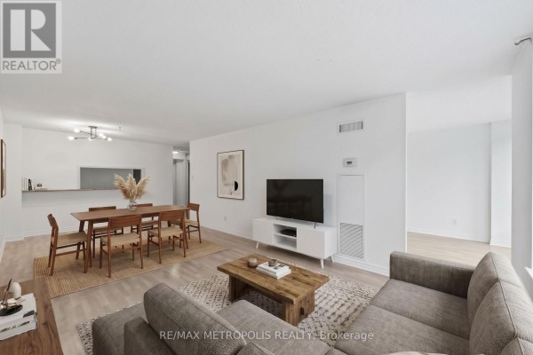 Living and dining area with a sofa, coffee table, dining table, and chairs. - 409 - 1485 Lakeshore Road E, Mississauga