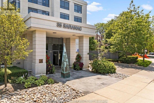 Entrance to a concrete apartment building with landscaping and a stone pathway. - 409 - 35 Saranac Boulevard, Toronto