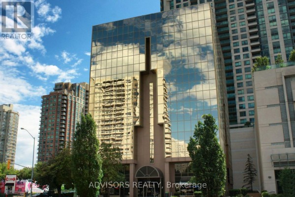 View of the golden glass commercial building from street level, with trees and blue sky. - 409 - 3660 Hurontario Street, Mississauga