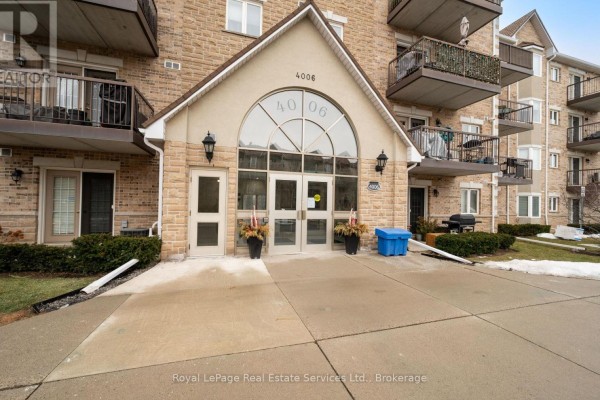 Entrance of the building featuring stone facade and large glass doors - 409 - 4006 Kilmer Drive, Burlington
