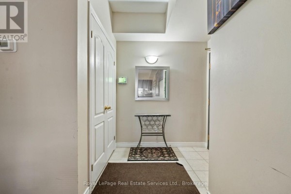 Kitchen with dark wood cabinets, white appliances, and tiled floor - 409 - 4006 Kilmer Drive, Burlington