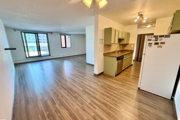 View of the open living area and kitchen with light wood flooring. - #409 10145 109 St Nw, Edmonton
