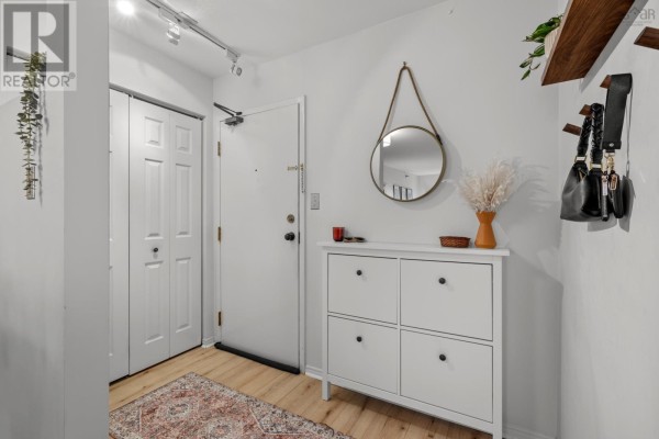 Entryway with a white shoe cabinet, round mirror, and double closet doors. - 409 93 Kearney Lake Road, Kearney Lake