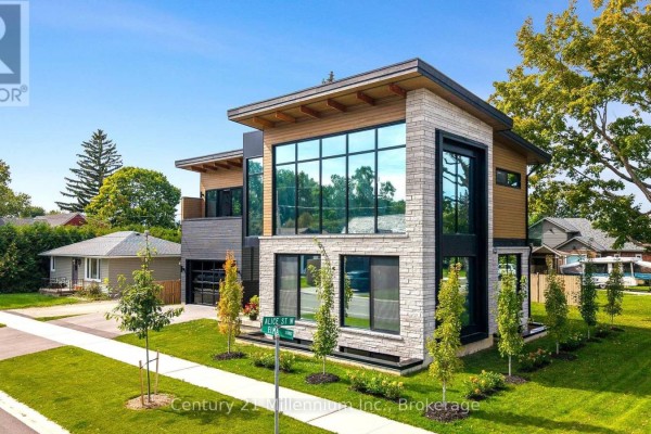 Front exterior of a modern home with large windows, stone and wood accents, and landscaping. - 41 Alice Street W, Blue Mountains