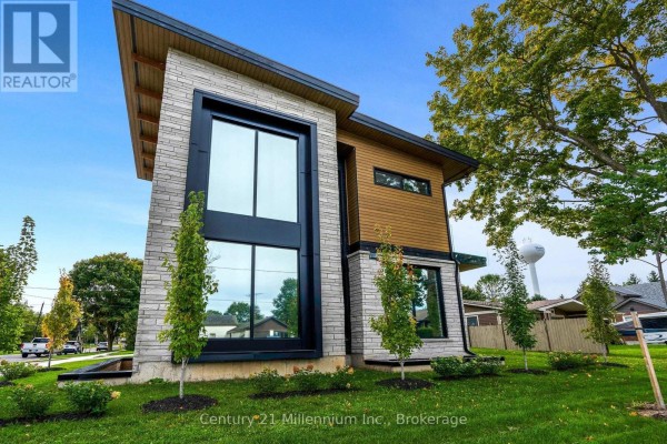 Side exterior of the home featuring large windows, stone facade, and wood accents under a sloped roof. - 41 Alice Street W, Blue Mountains