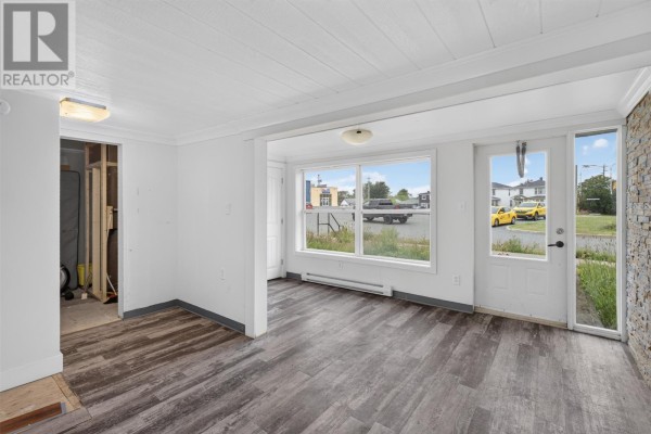 Interior room with white walls, wood-look flooring, and large windows overlooking the street. - 41 Cashin Avenue, St John S