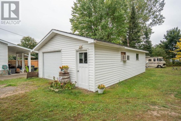 Detached white single-car garage with a large roll-up door and a side entrance door. - 41 Centre St, Sault Ste  Marie