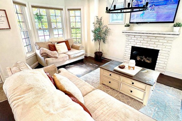 Living room with bay windows, fireplace, television, and sectional sofa. - 41 David Street, Ingersoll