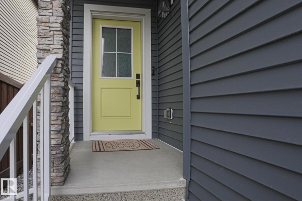 Close-up of the light yellow front door with a window and stone pillar. - 41 Elko Bn, St  Albert
