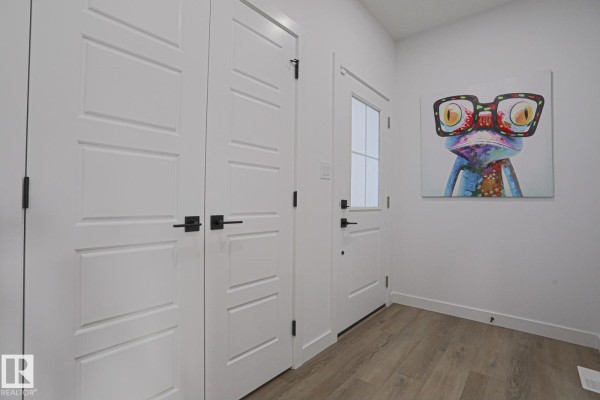 Interior hallway with white doors, a frosted glass door, and a colourful art print. - 41 Elko Bn, St  Albert