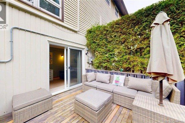 Outdoor deck with patio furniture and a sliding glass door leading into the house. - 41 Hillsview Crescent, Rothesay
