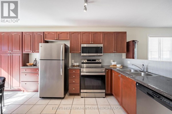 Kitchen view showing a stainless steel refrigerator, range, dishwasher, and ample cabinet storage. - 41 Irene Drive, Barrie