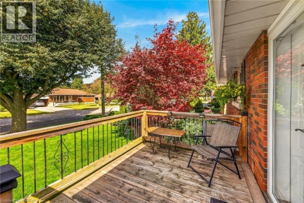 Wooden deck with a metal railing and a small table and chair set. - 41 Kensington Avenue, Brantford